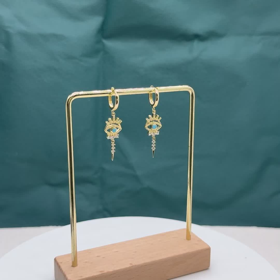 Um par de brincos de luxo com pingente sintético com incrustações de cobre e motivo do «olho do mal», um presente ideal para um encontro